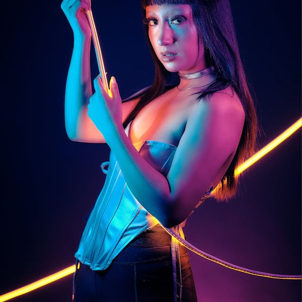 Woman practicing yoga with a neon lime accent glow.